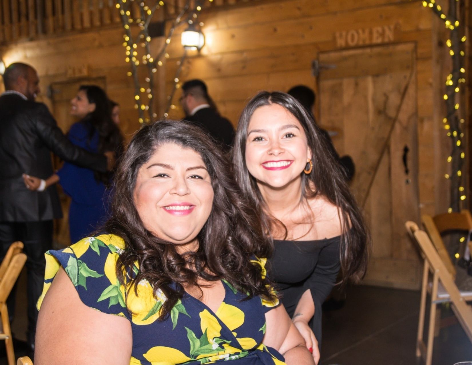 Two Latinx Employee Impact members smile for the camera at an event.